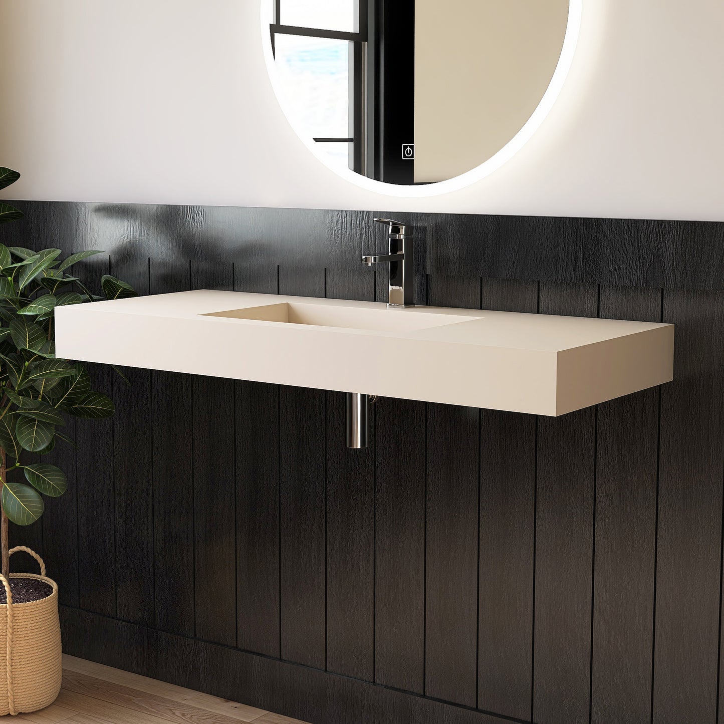 Modern bathroom vanity with wall mounted creamy beige sink against a black paneled wall.
