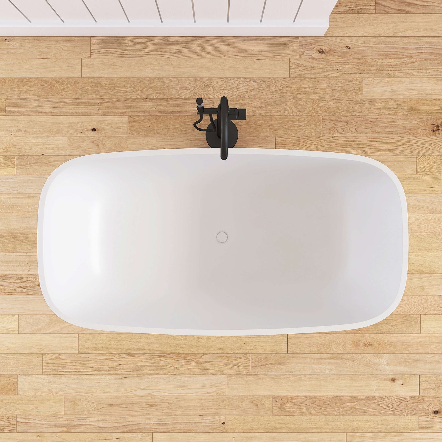 White freestanding bathtub on a wooden floor with a black faucet.