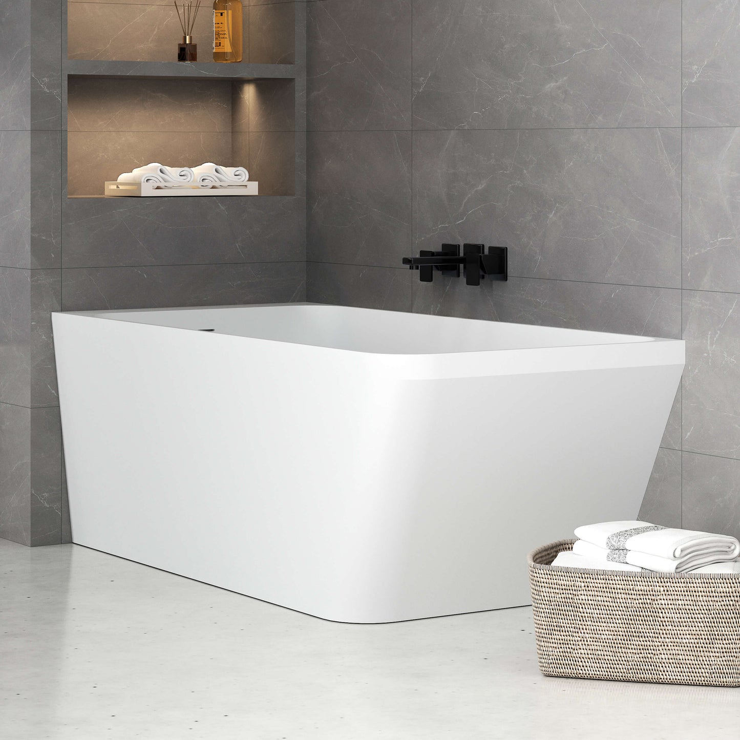 Modern bathroom with a white freestanding bathtub, gray tiled walls, and a basket of towels.