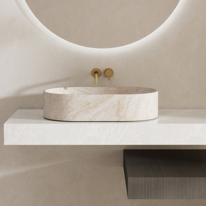 Marble pattern oval solid surface sink on a white countertop with a gold faucet.