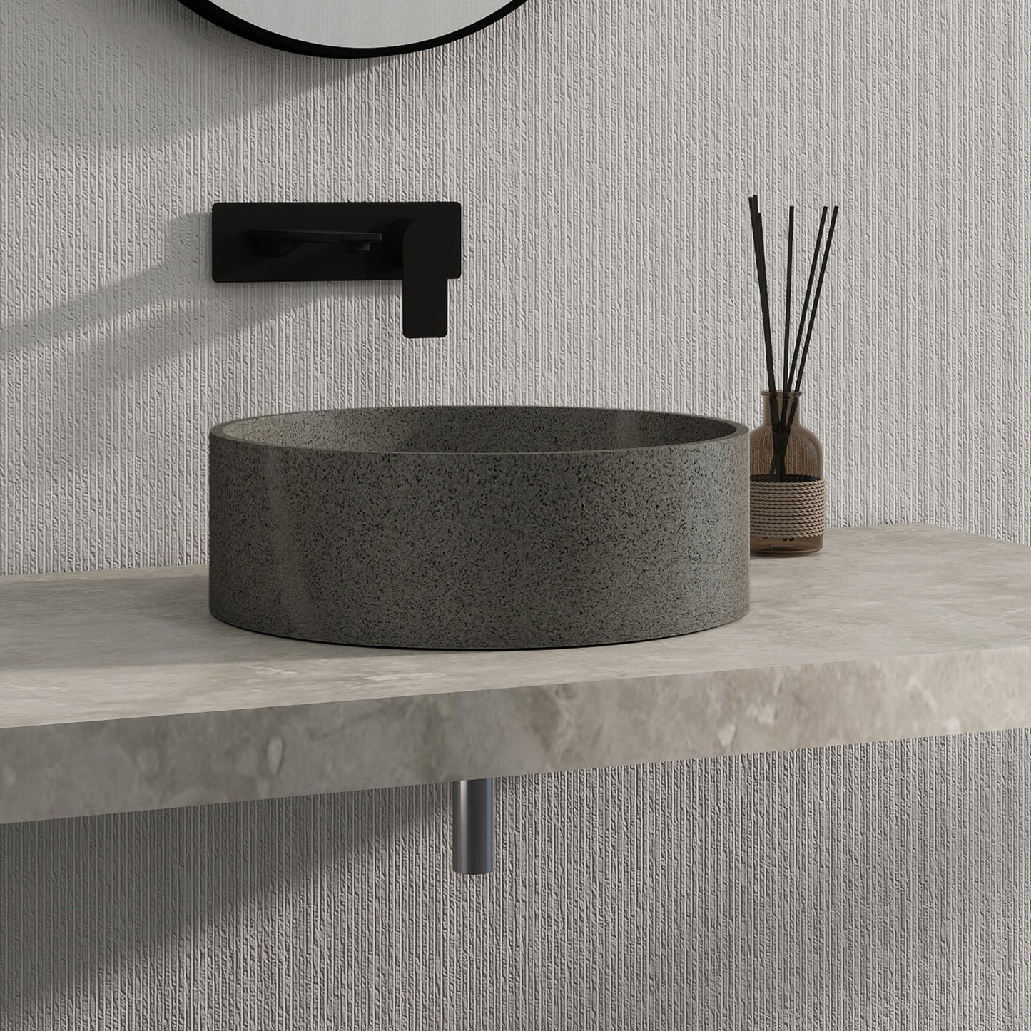 Dark gray solid surface stone sink on a light gray countertop with a textured wall background