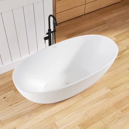 White freestanding bathtub on a wooden floor with a black faucet.