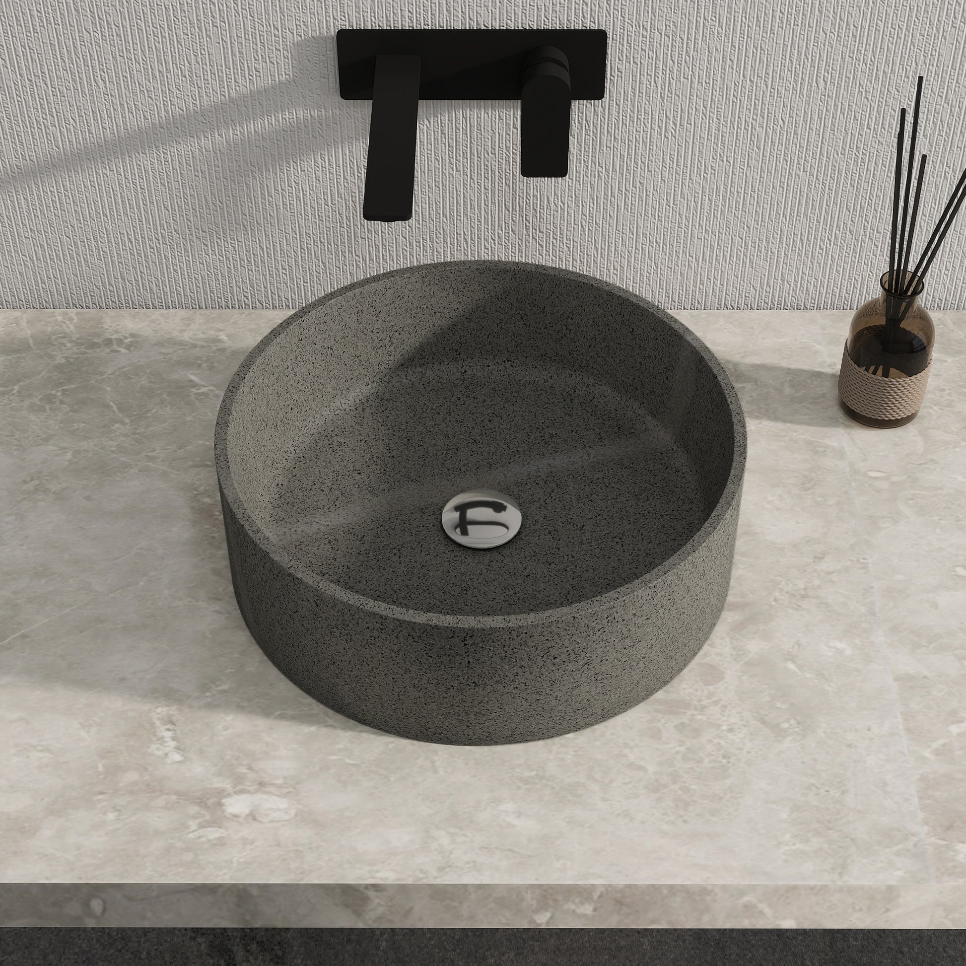 Dark gray solid surface stone sinkon a gray countertop with a black faucet.