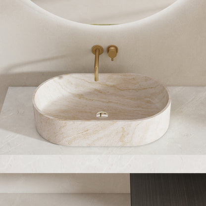 Marble pattern oval solid surface sink on a white countertop with a gold faucet.