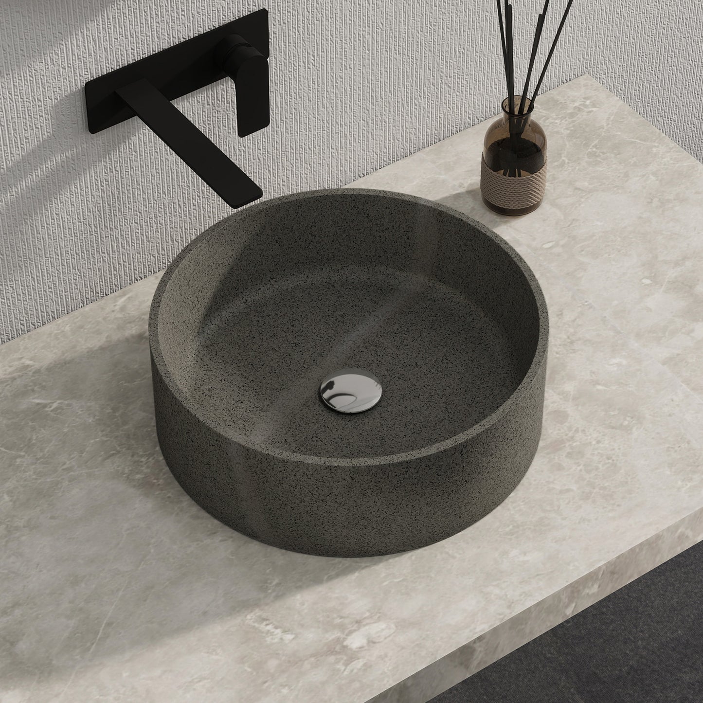 Dark gray solid surface stone sink on a light gray countertop with a black faucet.