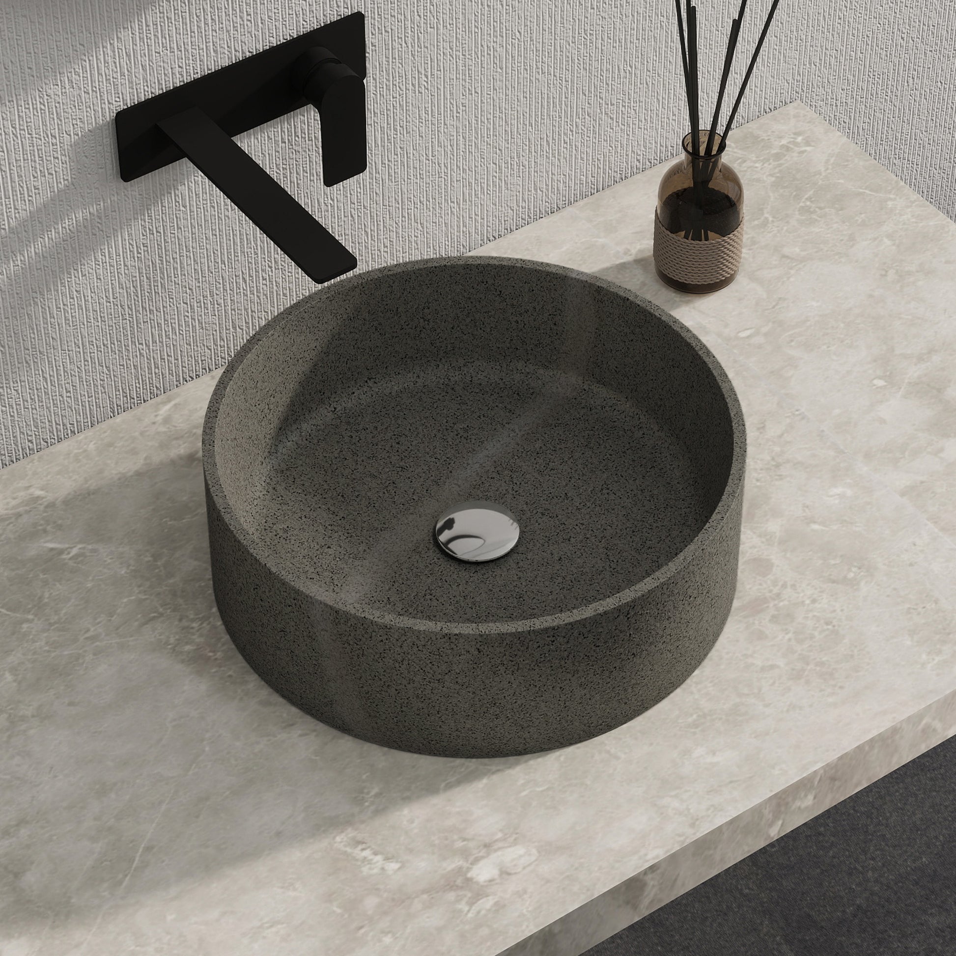 Dark gray solid surface stone sink on a light gray countertop with a black faucet.