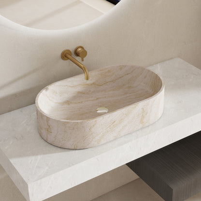 Marble pattern oval solid surface sink on a white countertop with a gold faucet.