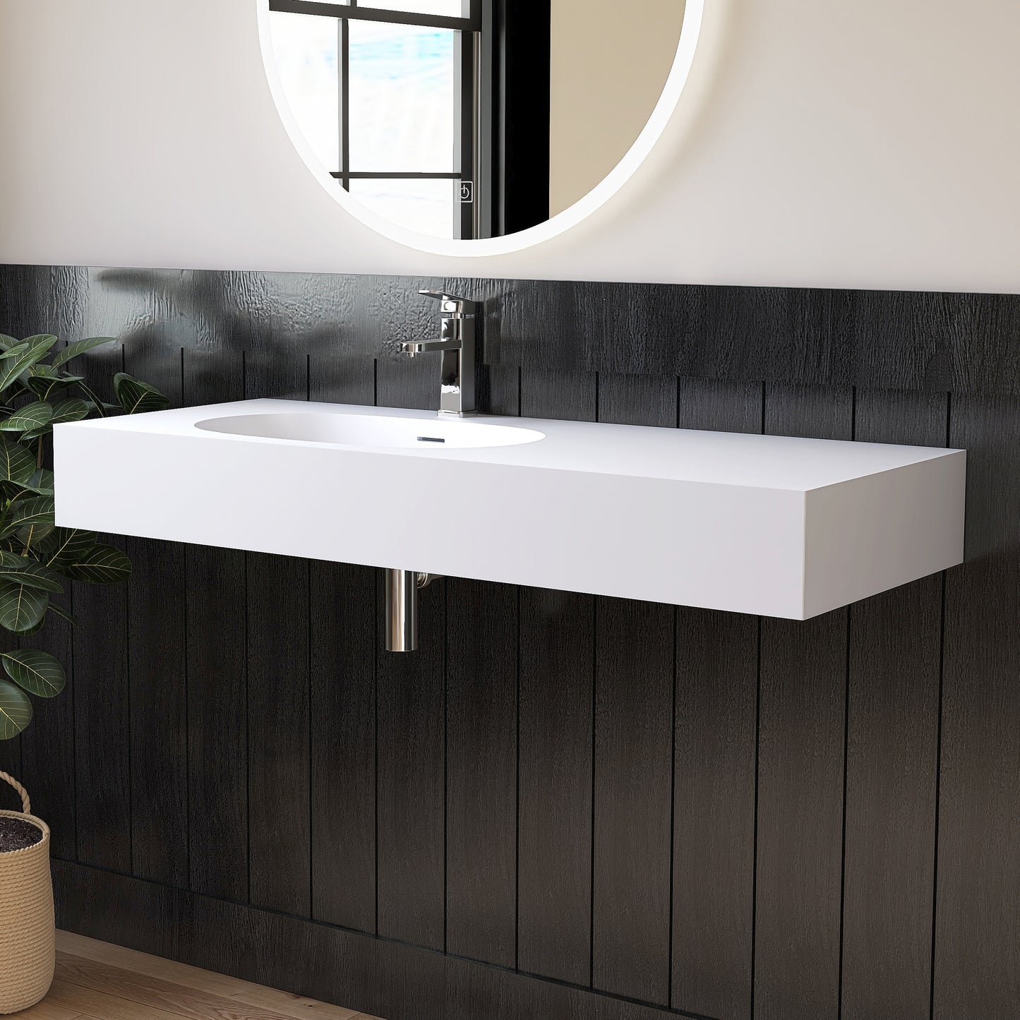 Wall mounted White sink mounted on a dark wooden wall with a round mirror above.