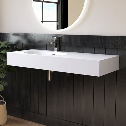 Wall mounted White sink mounted on a dark wooden wall with a round mirror above.