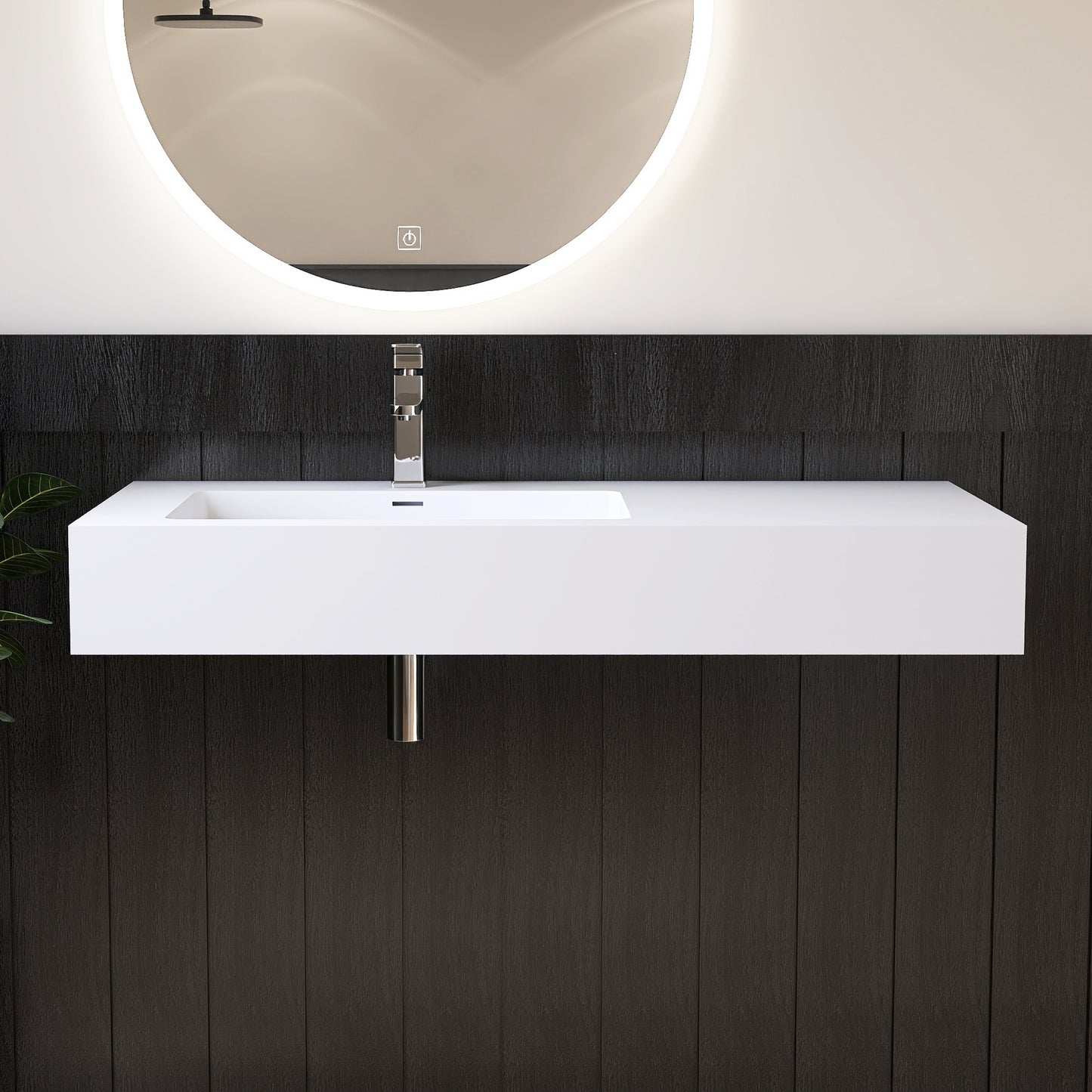Modern bathroom vanity with white wall mounted sink and round mirror on a dark wooden wall.