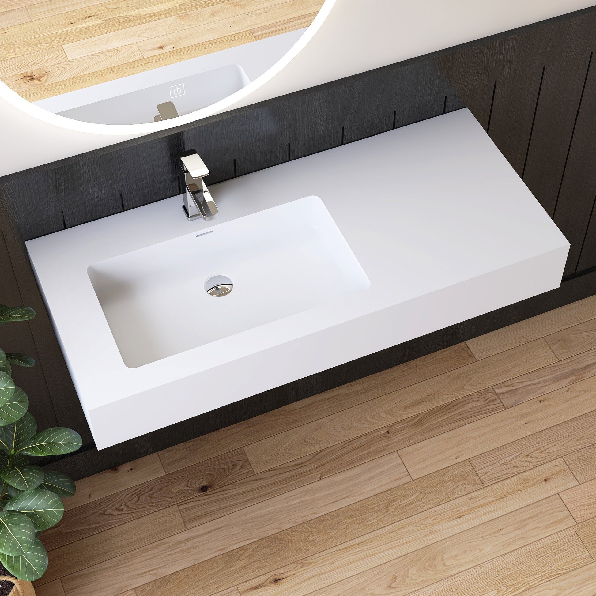 Bathroom vanity with white wall mounted sink and dark wood cabinets on a wooden floor.