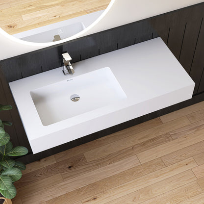 Bathroom vanity with white wall mounted sink and dark wood cabinets on a wooden floor.