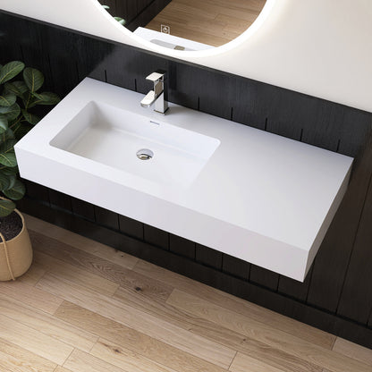 White wall mounted sink on a dark wooden wall with a mirror above it