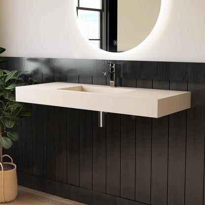 Modern bathroom vanity with wall mounted creamy beige sink against a black paneled wall.