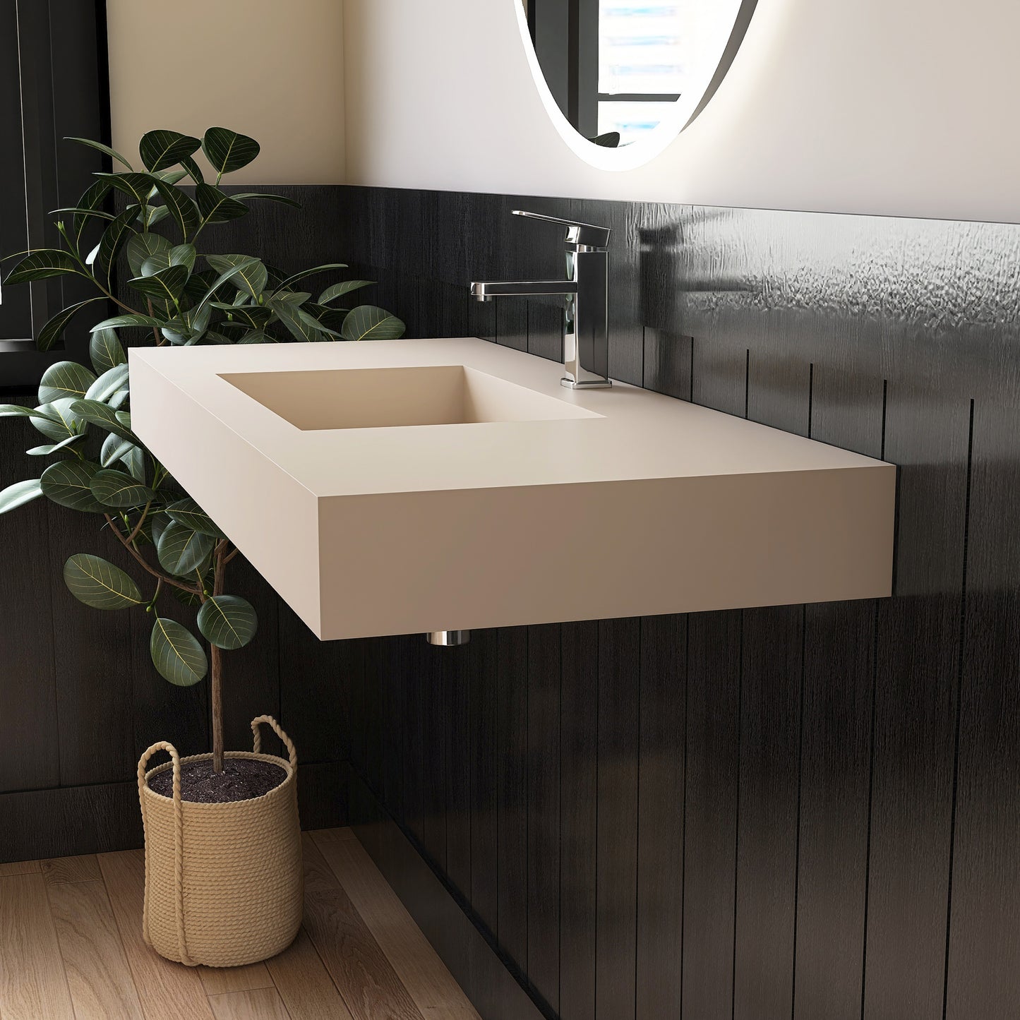Modern bathroom with a wall mounted creamy beige sink against a dark tiled wall, featuring a plant and basket.