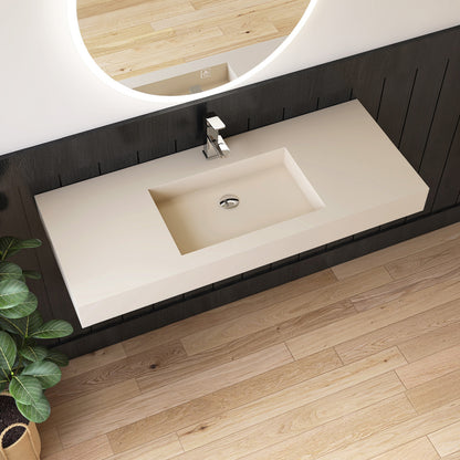 Bathroom vanity with wall mounted creamy beige sink, black cabinet, and wooden floor.
