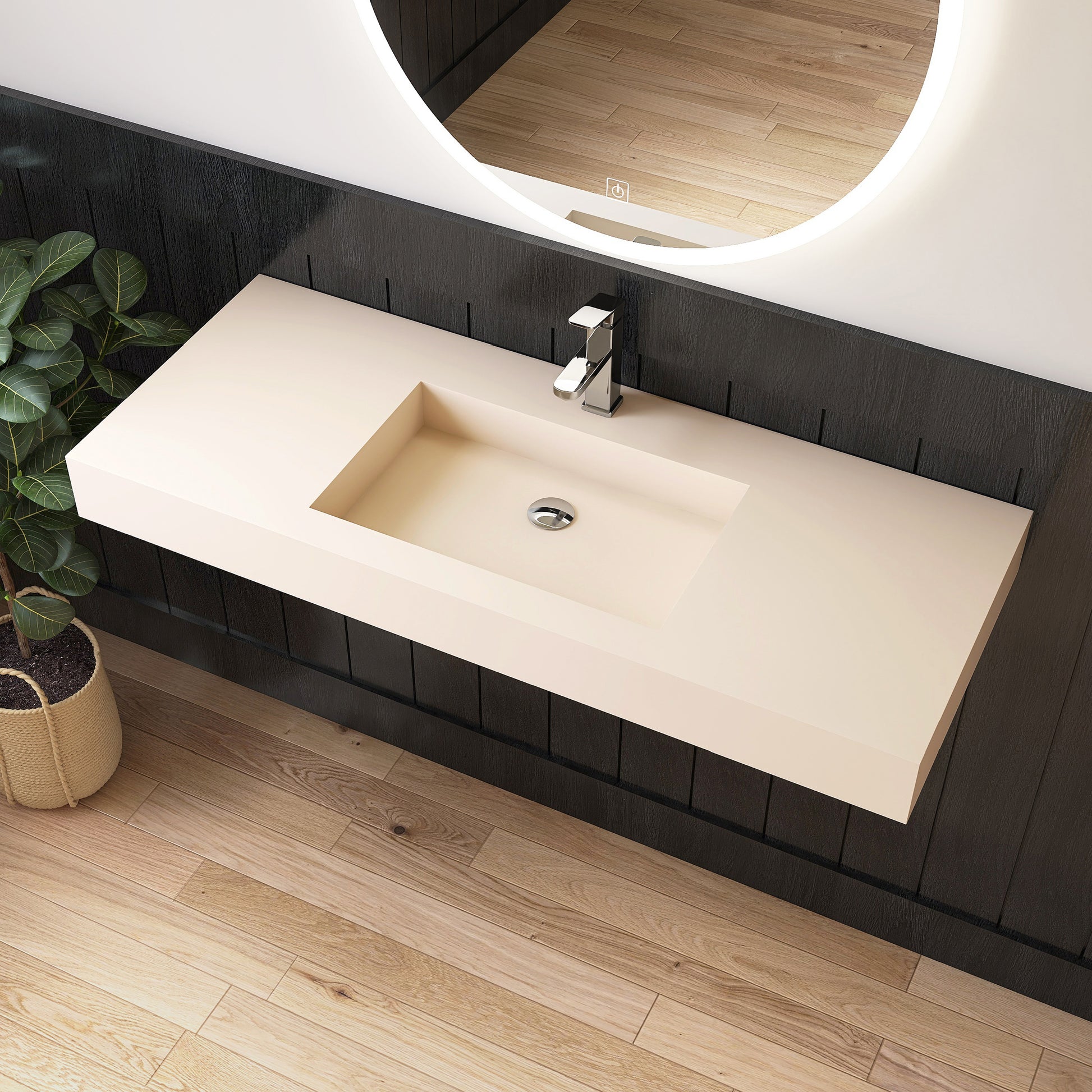 Bathroom vanity with wall mounted creamy beige sink and mirror in a modern bathroom setting.