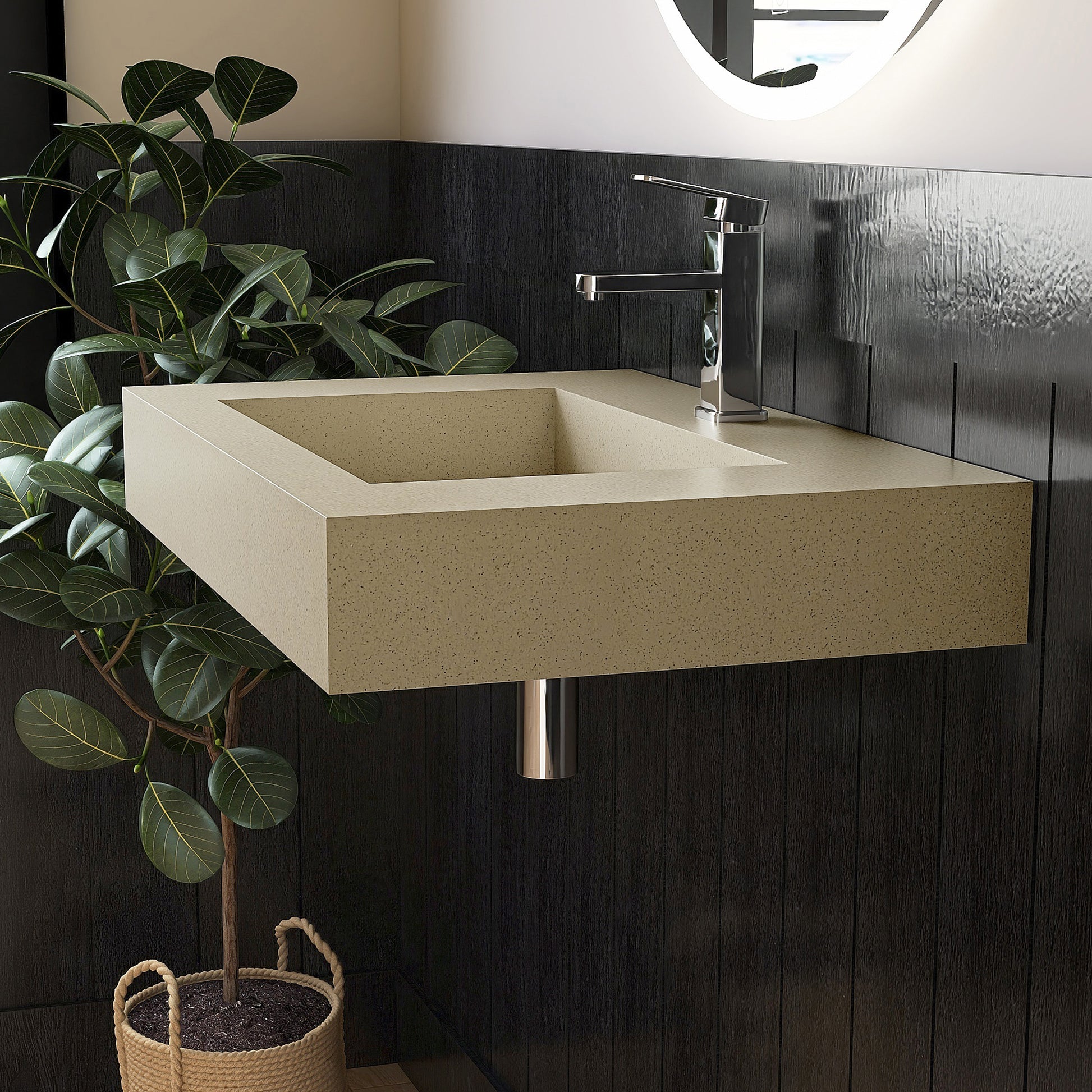 Beige wall mounted Bathroom sink with dark tiled wall and plant