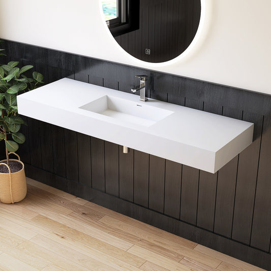 Modern bathroom with a long white sink against a dark wooden wall.