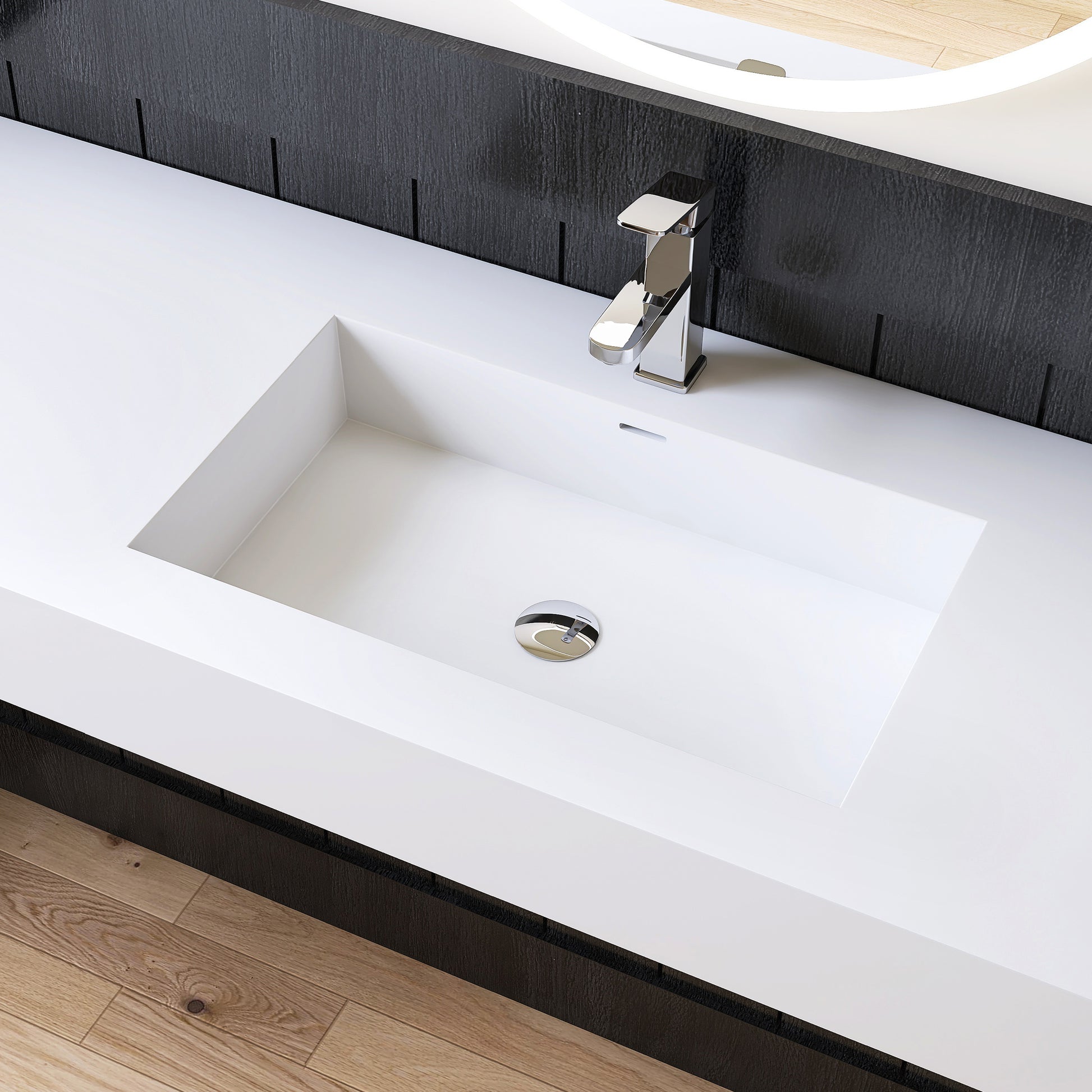 Modern white bathroom sink with chrome faucet against a black wall.