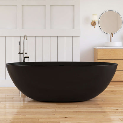 Black freestanding bathtub in a modern bathroom with wooden floor and white walls.