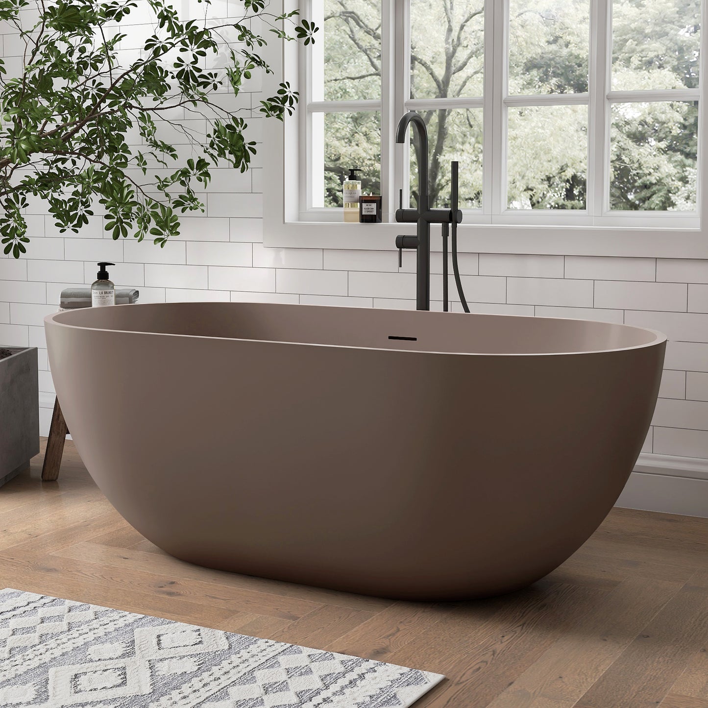 Grey-Coffee freestanding bathtub in a modern bathroom with a window and plant.