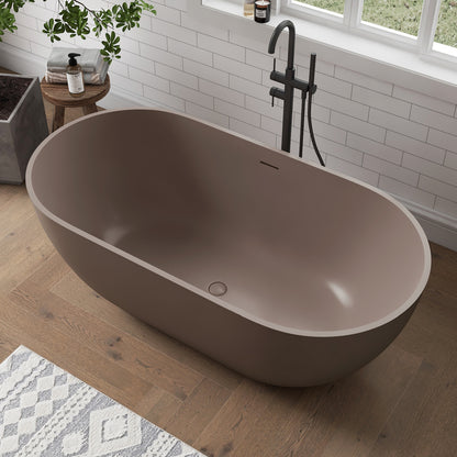 Grey-Coffee freestanding bathtub in a modern bathroom with wooden floor and white tiled wall.