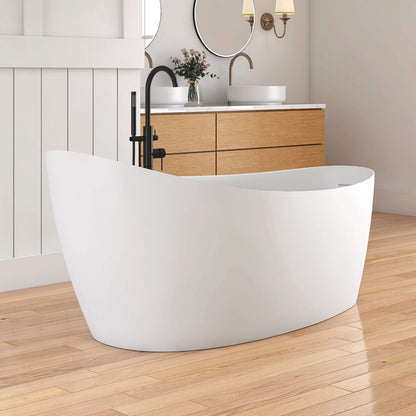 White freestanding bathtub in a modern bathroom with wooden vanity and floor.