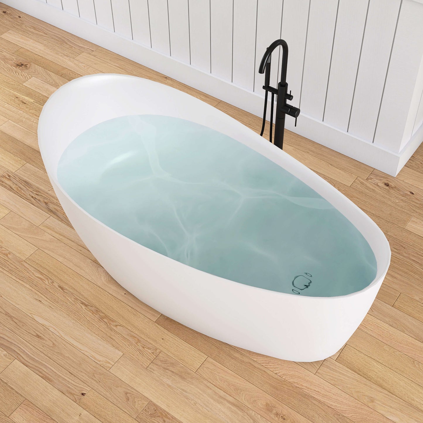 White freestanding bathtub with blue water on a wooden floor