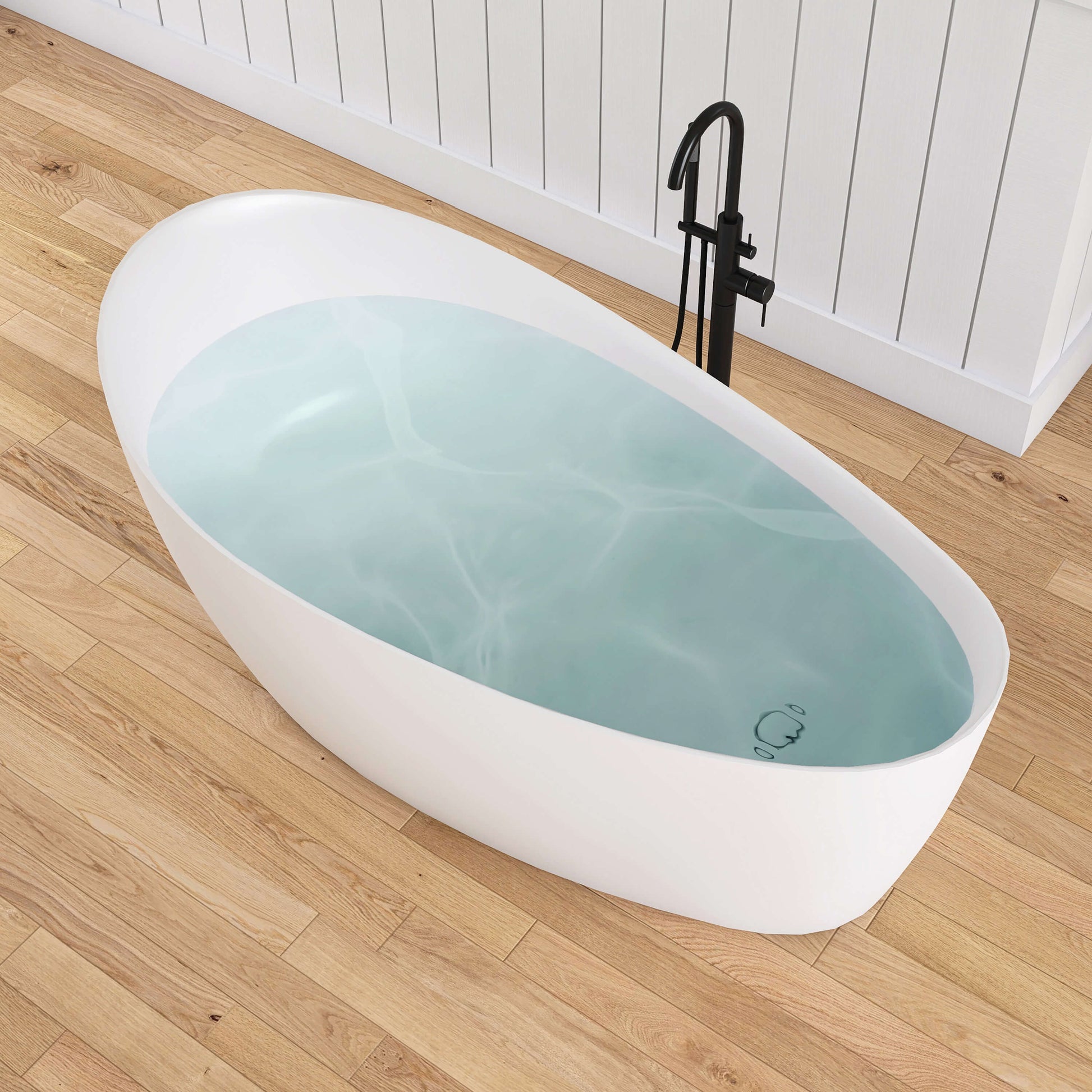 White freestanding bathtub with blue water on a wooden floor