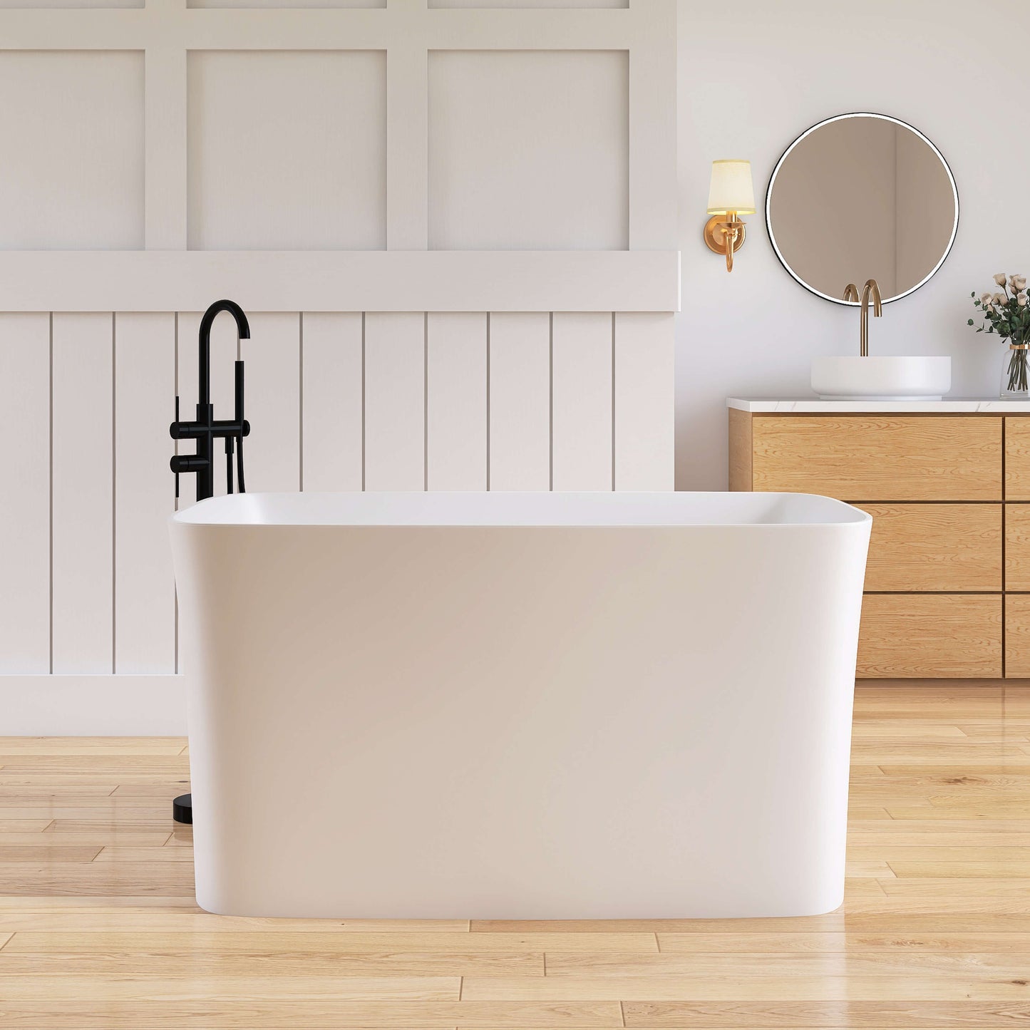 Modern bathroom with a freestanding bathtub, wooden vanity, and round mirror.