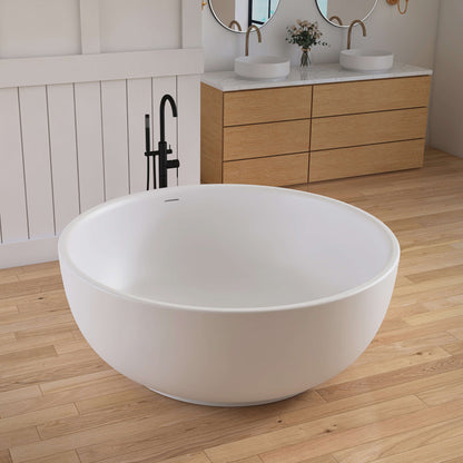 White freestanding bathtub in a modern bathroom with wooden vanity and mirrors.