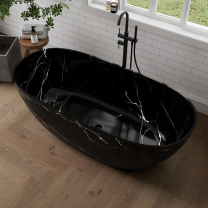 Black marble-patterned freestanding bathtub in a modern bathroom with a window and plant.