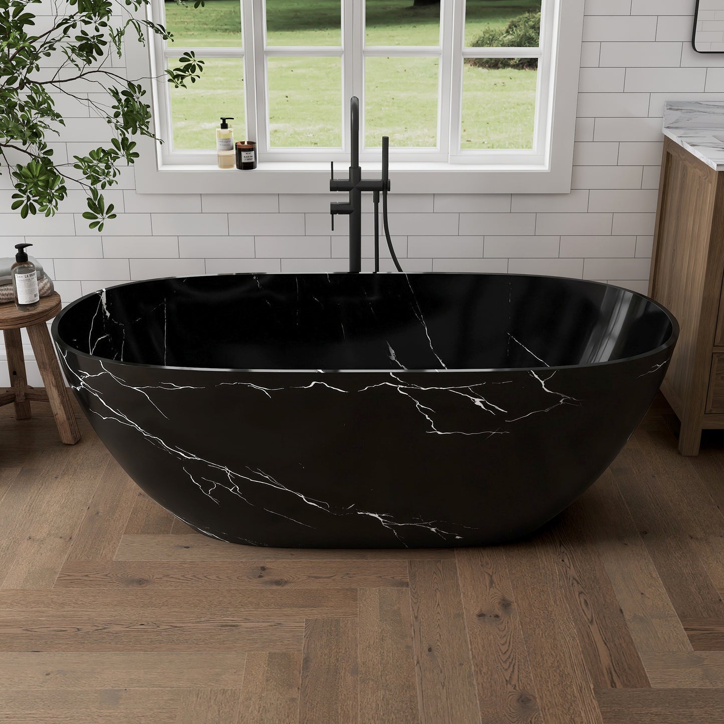 Black marble-patterned bathtub in a modern bathroom with a window and plant.