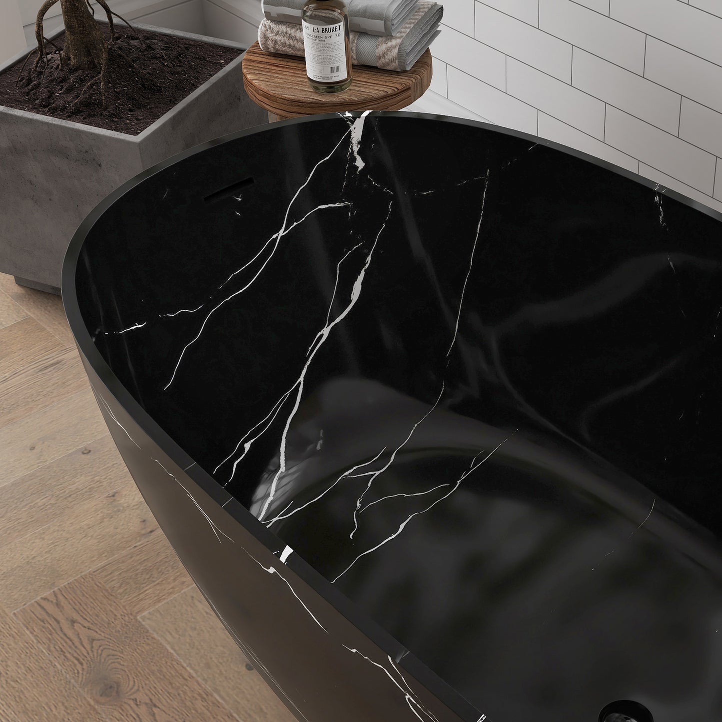 Black marble-patterned bathtub with water flowing into it in a bathroom setting.