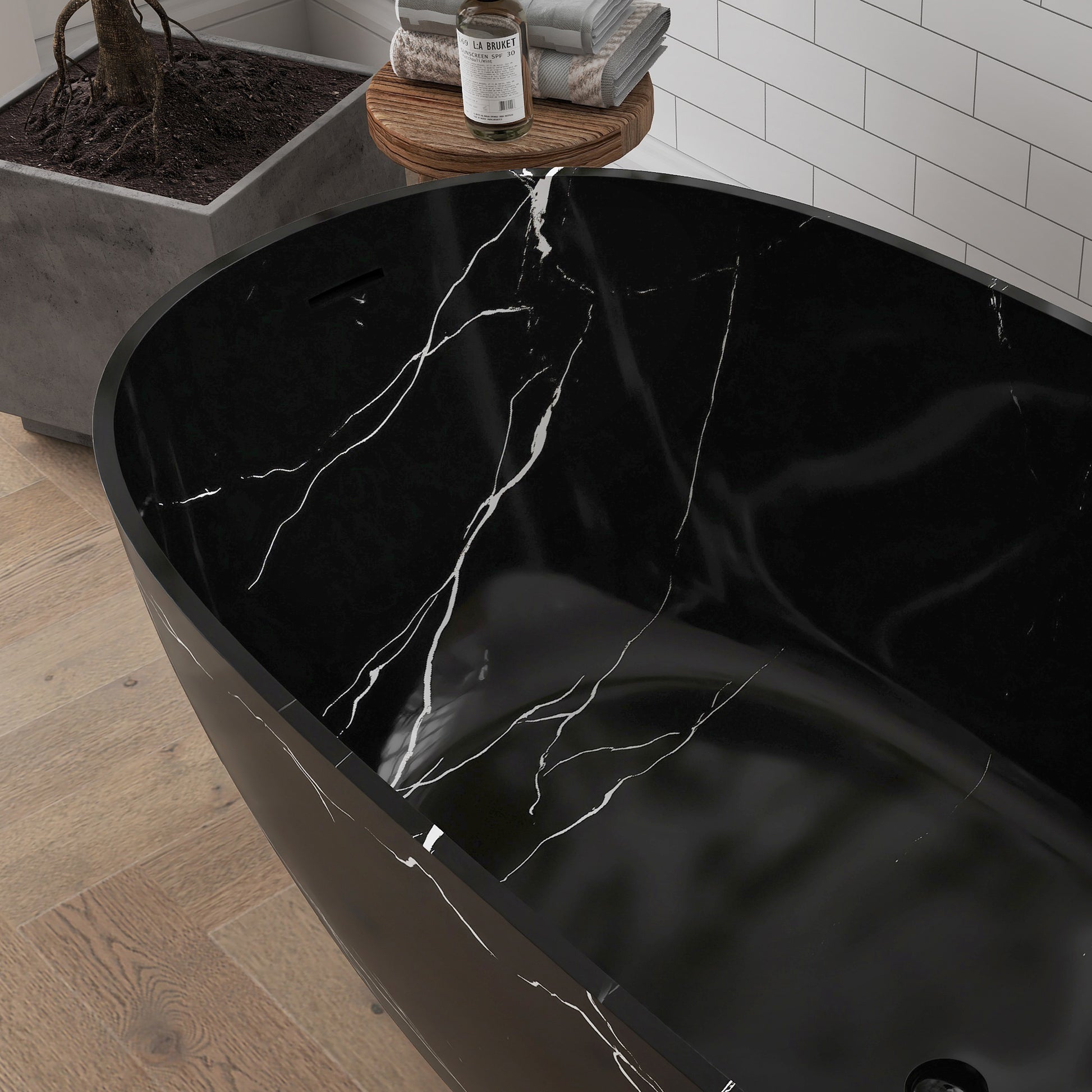 Black marble-patterned bathtub with water flowing into it in a bathroom setting.