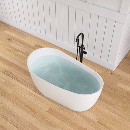 White freestanding bathtub with water on a wooden floor in a bathroom setting.