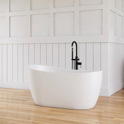 Modern bathroom with a freestanding bathtub, wooden vanity, and white tiled walls.