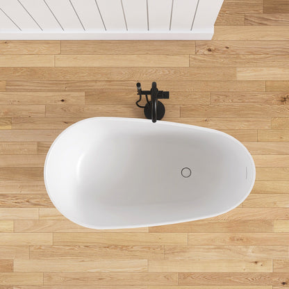 White freestanding bathtub on a wooden floor with a black faucet.