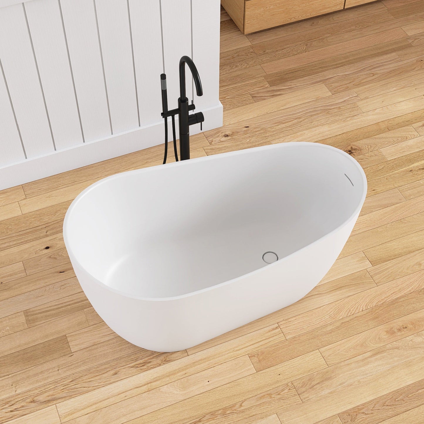 White freestanding bathtub on a wooden floor with a white wall in the background