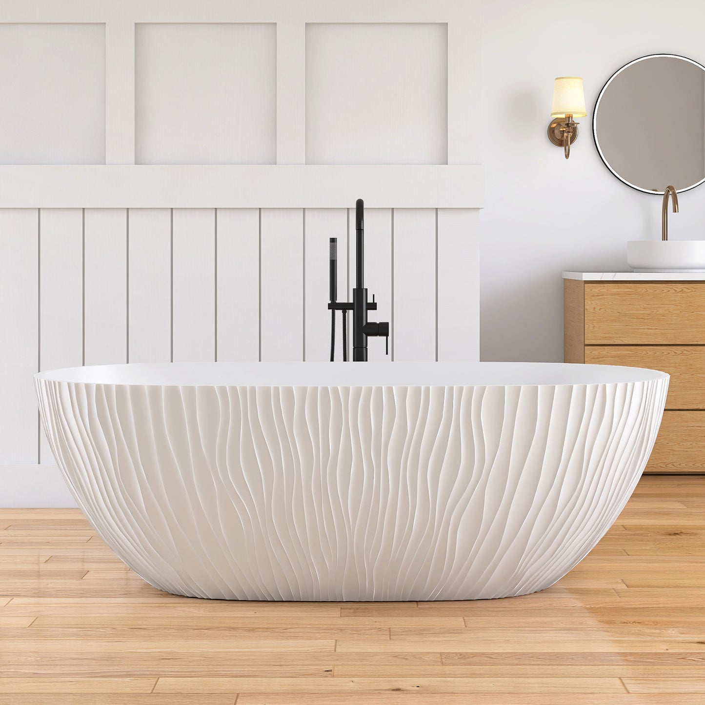 White freestanding bathtub in a modern bathroom with wooden flooring and a wooden cabinet.