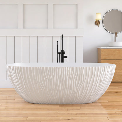 White freestanding bathtub in a modern bathroom with wooden flooring and a wooden cabinet.