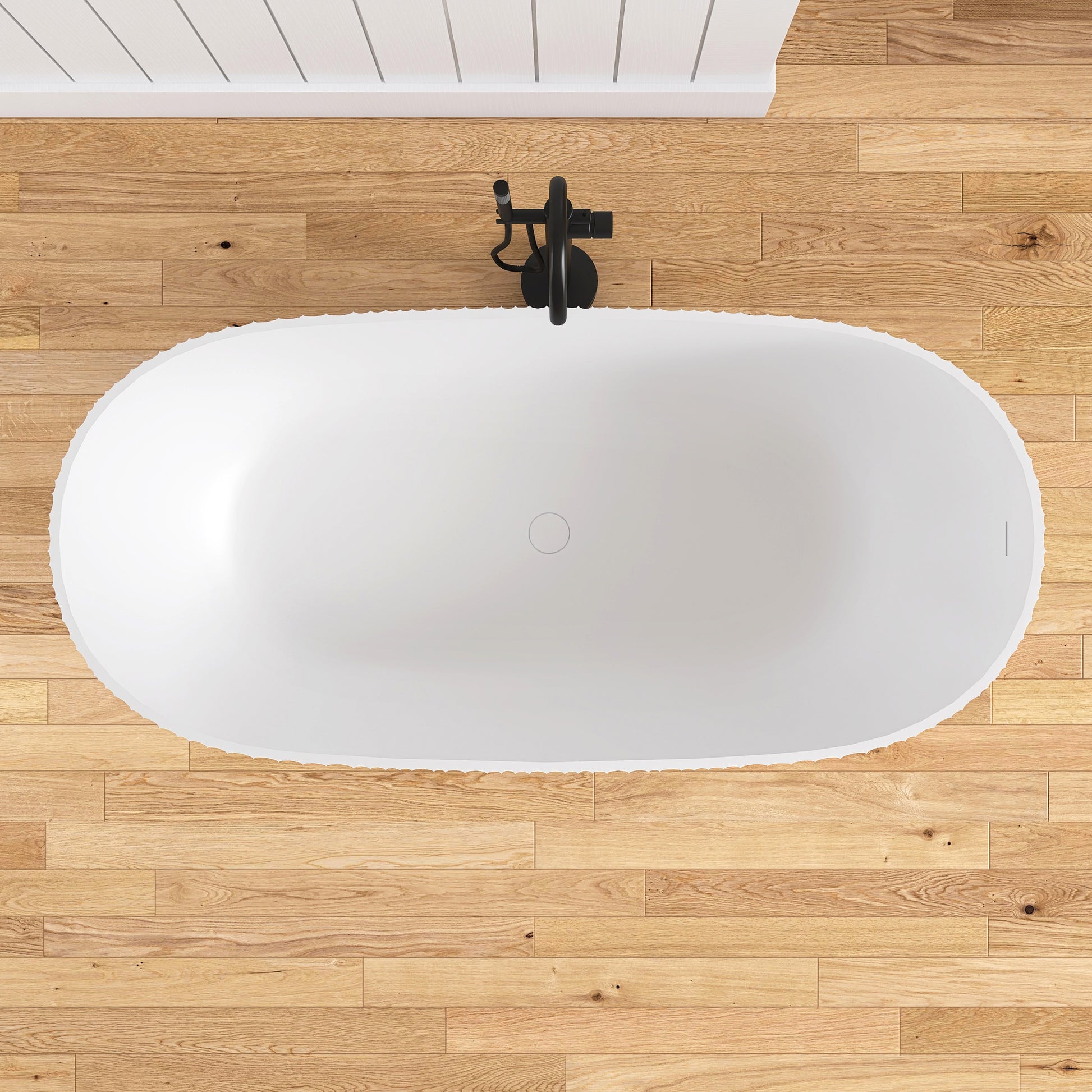 White freestanding bathtub on a wooden floor with a black faucet.