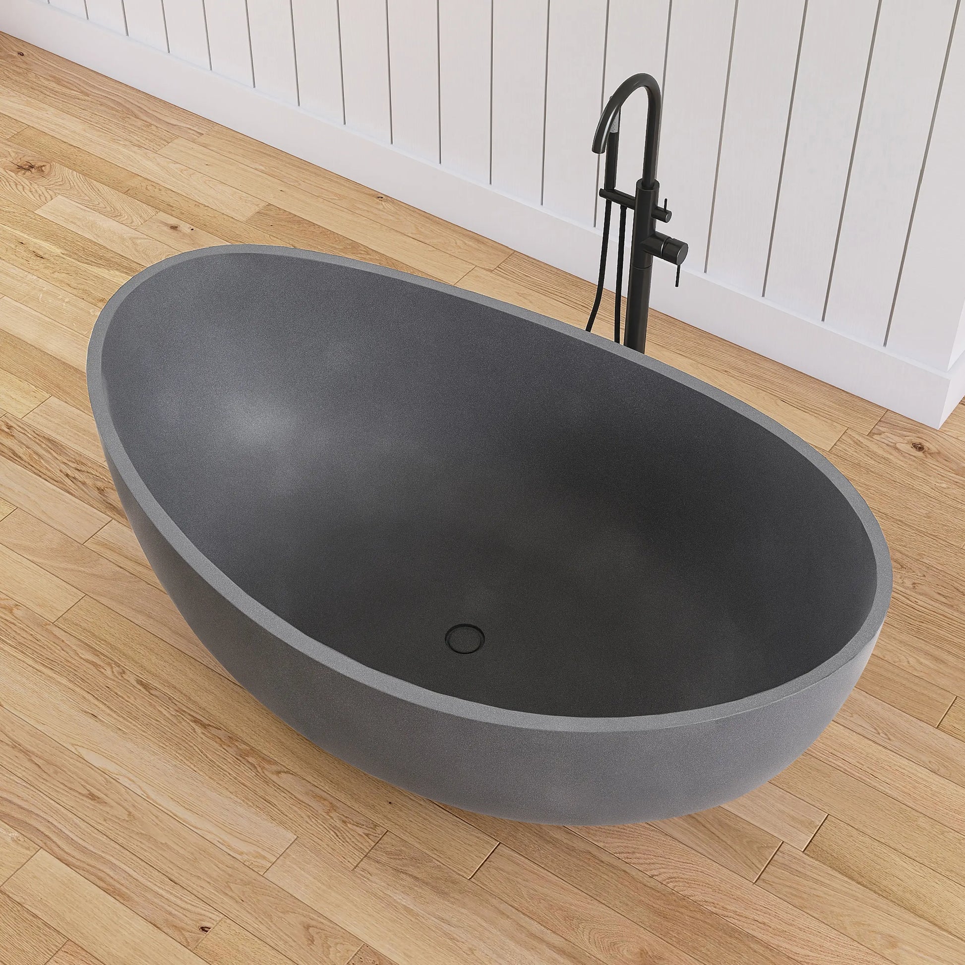 Gray freestanding bathtub on a wooden floor with a black faucet.